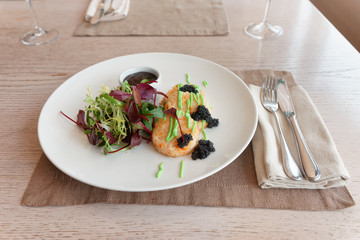 Crab cakes with salad mix, teriyaki sauce, seaweed caviar