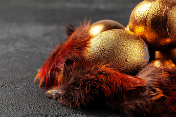 Golden Easter eggs on red bird feathers close up