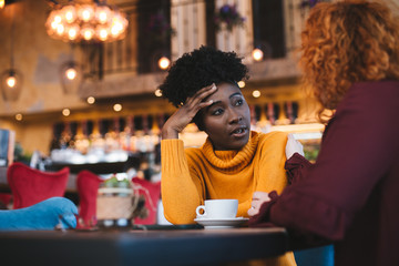 Two female friends talking about a problem one of them has. The red haired girl is supportive and understanding while the other is talking.