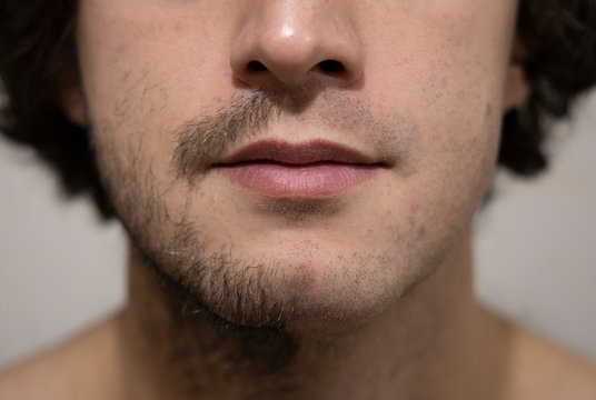 shaving before and after in one picture on ordinary young adult European white man close face portrait with focus on mouth lips