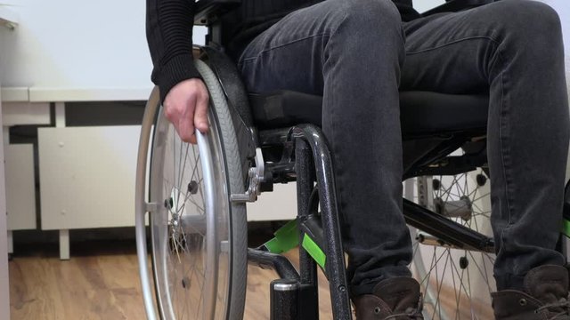 hand on a wheelchair, close-up, a young man who cannot walk