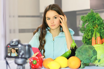 Teenage blogger explains to her followers how to eat healthy. Concept of communication among young people on the importance of healthy eating habits, vitamins and calories.