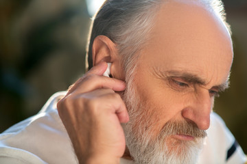 Close up picture of a man attaching wireless earphones