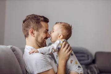 Foto op Plexiglas Adorable little blond boy playing with his caring father and trying to bite his nose. Family values. © dusanpetkovic1