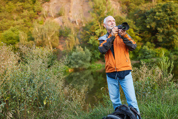 Senior als Landschaftsfotograf in der grünen Natur