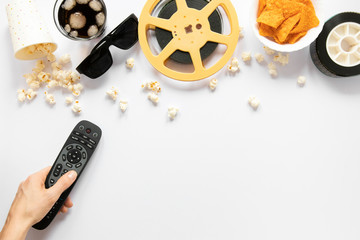 Film elements on white background and person holding a tv remote