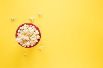 Popcorn bowl on yellow background with copy space