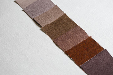 square pieces of multi-colored fabric laid out on a gray background