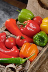 Red, green and yellow vegetables in a rustic tray. Top view.