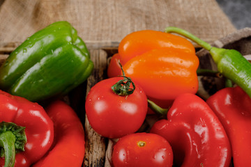 Seasonal vegetables in a rustic tray with water drops on them. Top view.