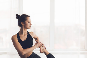 Fototapeta na wymiar Sporty young woman stretching on yoga mat