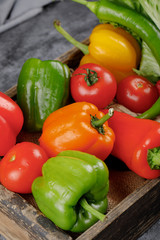 Fresh colorful peppers and tomatoes in a rustic tray.