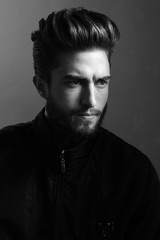 Close-up black and white portrait of a young handsome Caucasian male in studio. A man shows different human emotions.