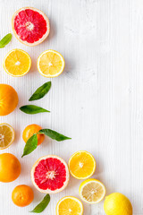 Citrus fruits frame - halfs of lemons, grapefruits, leaves - on white background top-down copy space