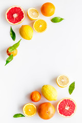 Citrus pattern. Cut lemon and grapefruits and leaves on white background top-down copy space