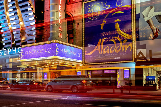 Night view with busy traffic light trails of the New Amsterdam Theatre showing Disney’s Aladdin musical on Broadway in Manhattan on October 25, 2016 in New York City, United States