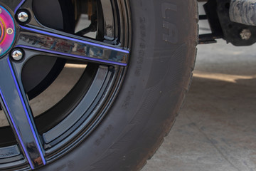 Close - up  the black tire wheels. Sunlight on the surface of the alloy wheel rim of the small...