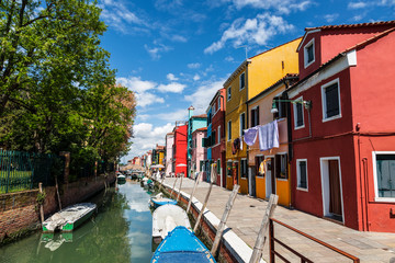Cityscape on the island of Burano with a canal and bright colorful buildings on the shores, Venice, Italy