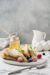 Tasty traditional russian pancakes with blueberry on white scandinavian plate. Pancake week. Shrovetide. Regional food. Close up. Vertical format.