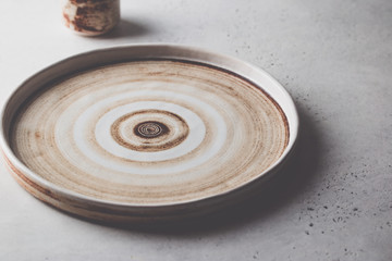 Empty plate and sauce bowl on grey stone background