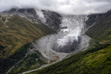 Aerial view to Adishi icefall and tongue with small waterfall on it moraine and kar in mountains of...