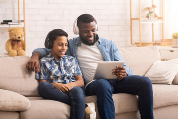 Cheerful Black Father And Son Watching Funny Videos On Digital Tablet
