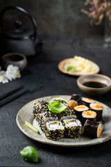 Set of sushi and maki with soy sauce over black background. Top view with copy space