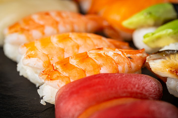 Set of sushi and maki with soy sauce over black background. Top view with copy space