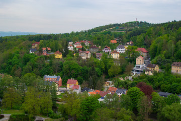 Typical colorful czech houses in Loket, a picturesque town in Czech Republic, with the green trees of the mountain at the background