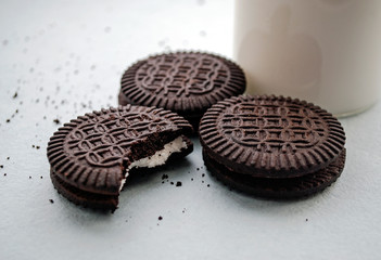 Delicious sandwich cookies with a glass of milk. Gluten-free cornmeal cookies, black.  healthy eating concept, flat lay White background
