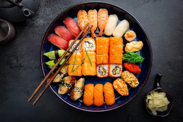Fotobehang Sushi bar Set sushi en maki met sojasaus op zwarte achtergrond. Bovenaanzicht met kopieerruimte