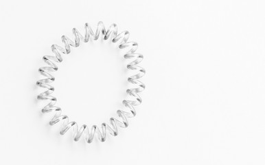 Transparent elastic spiral hair band for women or girls isolated on white background. With clipping path. Modern plastic transparent rubber, tie for girlish long hair hairstyles. copy space