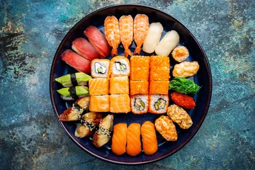 Vlies Fototapete Sushi-bar Satz Sushi und Maki mit Sojasauce über blauem Steinhintergrund. Draufsicht mit Kopienraum