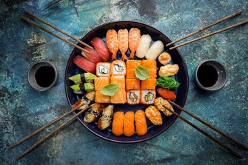 Foto op geborsteld aluminium Sushi bar Set sushi en maki met sojasaus over blauwe stenen achtergrond. Bovenaanzicht met kopieerruimte
