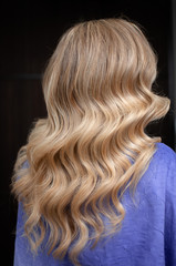 Naklejka premium Long hair of a blonde woman with wave hairstyle