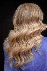 Naklejka premium Long hair of a blonde woman with wave hairstyle