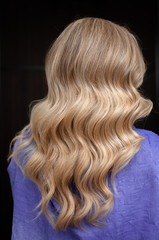 Long hair of a blonde woman with wave hairstyle