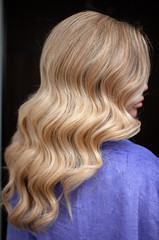 Naklejka premium Long hair of a blonde woman with wave hairstyle