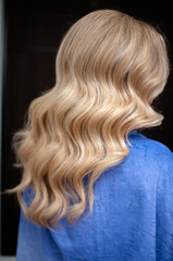 Naklejka premium Long hair of a blonde woman with wave hairstyle