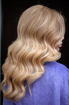 Long hair of a blonde woman with wave hairstyle