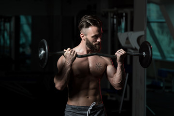 Fototapeta na wymiar Athlete Working Out Biceps In A Gym