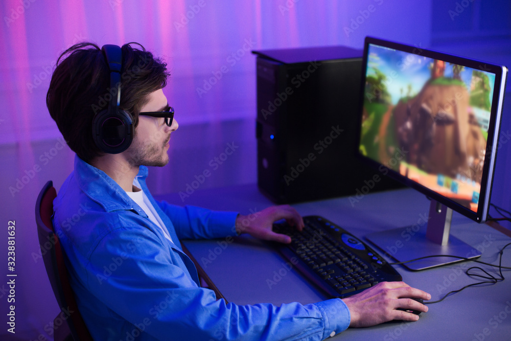 Poster unrecognizable millennial guy playing computer games at home