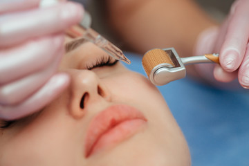 Beautiful girl woman in spa salon,facial rejuvenation procedure.Visit a beautician.Hyaluronic acid rejuvenation beauty injections mesotherapy.Concept of mesotherapy.Cosmetology.Mezoroller,mesotherapy, - obrazy, fototapety, plakaty