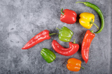 Selection of sweet bell peppers and chilies on the blue stone. Top view.