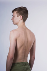Naklejka premium Portrait of a young brown-haired man with a naked torso, a view from the back and a full-face portrait