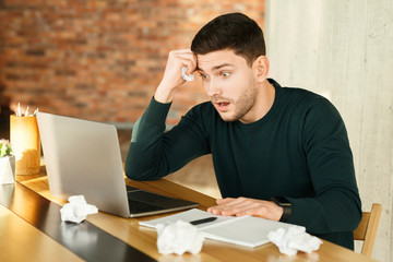 Overworked Young Man At Laptop Crumpling Paper Working In Office