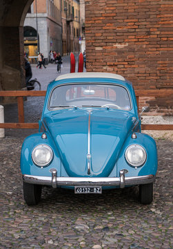 Vintage beetle with a pair of wooden skis on the rack. This car was built in 1961. Ferrara, Italy - March 25, 2017.