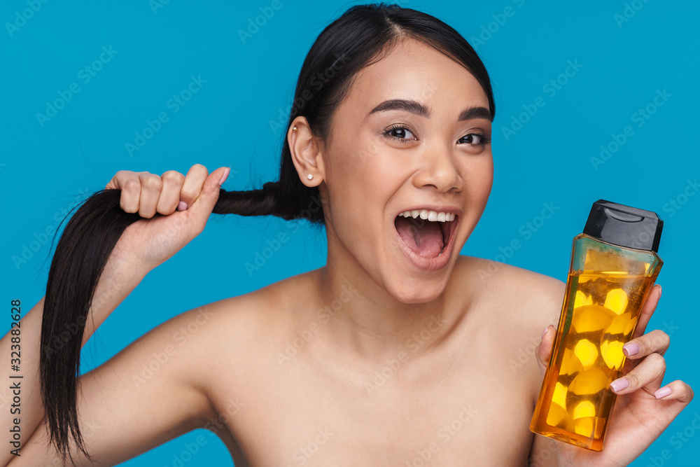 Canvas Prints Optimistic young woman holding bottle with shampoo.