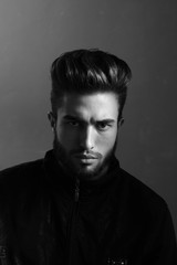 Close-up black and white portrait of a young handsome Caucasian male in studio. A man shows different human emotions.