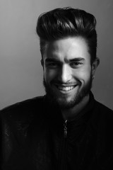 Close-up black and white portrait of a young handsome Caucasian male in studio. A man shows different human emotions.